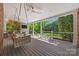Covered porch with a porch swing, ceiling fans, and a beautiful view of the backyard at 7700 Red Oak Ln, Charlotte, NC 28226