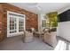 Cozy covered porch with wicker furniture, brick siding, and ceiling fan at 7700 Red Oak Ln, Charlotte, NC 28226