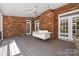 Covered porch featuring a porch swing, brick accents, and multiple ceiling fans at 7700 Red Oak Ln, Charlotte, NC 28226