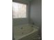 Bathroom featuring a large bathtub with shower fixture and tile surround at 7814 Rolling Meadows Ln, Huntersville, NC 28078