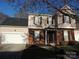 Charming two-story home featuring a brick facade, neutral siding, and an attached two-car garage at 7814 Rolling Meadows Ln, Huntersville, NC 28078
