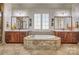 An elegant bathroom featuring a large soaking tub, dual sinks, and tile flooring and neutral-toned mosaic tile accents at 820 Cooks Cove Rdg, Lake Wylie, SC 29710