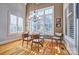 Sun-filled dining area with large windows, plantation shutters, modern chandelier, and hardwood floors at 820 Cooks Cove Rdg, Lake Wylie, SC 29710