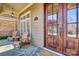 Inviting front porch with stone flooring, wood door, seating, and brick accents at 820 Cooks Cove Rdg, Lake Wylie, SC 29710