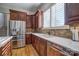 Gourmet kitchen with stainless steel appliances, wood cabinets, quartz countertops, and shutters on the window at 820 Cooks Cove Rdg, Lake Wylie, SC 29710