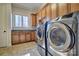 Bright laundry room with front loading washer and dryer, custom cabinetry, and granite countertops at 820 Cooks Cove Rdg, Lake Wylie, SC 29710