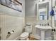 Charming powder room with wainscoting, pedestal sink, and stylish fixtures for guests at 820 Cooks Cove Rdg, Lake Wylie, SC 29710