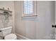 A cozy powder room with a toilet, small shelf, and a window with a view at 820 Cooks Cove Rdg, Lake Wylie, SC 29710