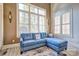 Cozy sitting area with a blue sofa, hardwood floors, decorative sconces, and plantation shutters at 820 Cooks Cove Rdg, Lake Wylie, SC 29710
