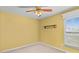 An Empty bedroom with yellow walls, neutral carpets, and a ceiling fan at 8260 Graham Rd, Denver, NC 28037