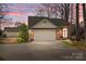 Lovely brick home featuring an attached two-car garage and mature trees against a vibrant sunset backdrop at 8260 Graham Rd, Denver, NC 28037