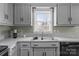 Bright kitchen with a window view, double basin sink, and gray countertops at 8260 Graham Rd, Denver, NC 28037