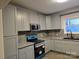 Well-lit kitchen featuring gray cabinets and appliances still in the package at 84 13Th Se St, Hickory, NC 28601