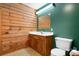 Cozy bathroom featuring wooden walls, single sink vanity and tiled floors at 1007 Mistywood Ln, Concord, NC 28027