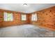 Inviting bedroom featuring wood paneled walls, plush carpet, and large windows for natural light at 1007 Mistywood Ln, Concord, NC 28027