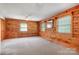 Inviting bedroom features knotty pine walls, plush carpeting, and natural light at 1007 Mistywood Ln, Concord, NC 28027