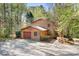 Aerial view of log cabin home with two-car garage nestled in the woods at 1007 Mistywood Ln, Concord, NC 28027