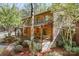 Charming log home with a covered porch, stone foundation, and landscaped yard at 1007 Mistywood Ln, Concord, NC 28027