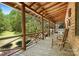 Log home front porch with chairs and a beautiful view of the landscaped yard at 1007 Mistywood Ln, Concord, NC 28027