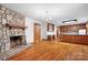 Open-concept living area with stone fireplace, hardwood floors, and adjoining kitchen at 1007 Mistywood Ln, Concord, NC 28027