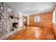 Cozy living room features a stunning stone fireplace, wood paneled walls, and hardwood flooring at 1007 Mistywood Ln, Concord, NC 28027