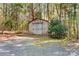 An exterior view of the wooden outbuilding with double doors nestled in the trees at 1007 Mistywood Ln, Concord, NC 28027