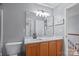 Bathroom with wood vanity, white countertop, large mirror, and modern light fixture at 1016 Council Fire Cir, Indian Trail, NC 28079