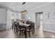 Bright dining room with modern light fixture, wooden table set, large windows, and neutral wall paint at 1016 Council Fire Cir, Indian Trail, NC 28079