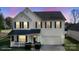 Charming two-story home with black shutters, a covered porch, a two-car garage, and manicured landscaping at 1016 Council Fire Cir, Indian Trail, NC 28079