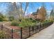 Well-manicured backyard with mature trees and elegant black metal fencing surrounding the property at 106 Brookwood Ln, Taylorsville, NC 28681