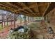 Backyard view from under the deck showcasing a pond, stone walkway, and landscaping at 106 Brookwood Ln, Taylorsville, NC 28681