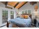 Comfortable bedroom boasts natural light, wood ceiling, and access to a private balcony at 106 Brookwood Ln, Taylorsville, NC 28681