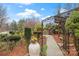 Detailed landscaping leading to wooden deck with mature trees and flower details at 106 Brookwood Ln, Taylorsville, NC 28681