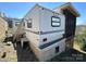 Home exterior with white RV and screened porch, partially overgrown lot at 108 Robin Ln, New London, NC 28127