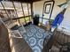 The covered deck showcases an outdoor seating area adjacent to the RV entrance, with a rocking chair and ample space at 108 Robin Ln, New London, NC 28127