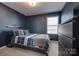 Bedroom featuring navy walls, plush bedding, and a window providing natural light at 11120 Pagebrook Ln, Charlotte, NC 28214