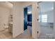 Hallway view showcasing access to a bedroom with navy walls and an adjacent bathroom at 11120 Pagebrook Ln, Charlotte, NC 28214