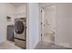 Laundry room with modern front-loading washer and dryer, adjacent to a bathroom at 11120 Pagebrook Ln, Charlotte, NC 28214