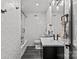 A modern bathroom with textured tile walls, dark vanity, a shower/tub, and sleek fixtures at 1300 Queens Rd # 408, Charlotte, NC 28207