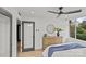 Bedroom featuring a hardwood floor, a dresser with decor, a round mirror, and a large window at 1300 Queens Rd # 408, Charlotte, NC 28207