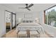 A bright main bedroom with a large window, ceiling fan and en suite bathroom behind a sliding door at 1300 Queens Rd # 408, Charlotte, NC 28207