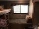This is a bunk room with a window, overhead storage, and modern wood paneling at 137 Landlubber Trl, Mount Gilead, NC 27306