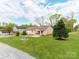 Landscaped front yard view of a well-maintained single-story brick home with mature trees at 1401 Birch St, Kannapolis, NC 28081