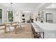Open concept kitchen features white cabinets, island with seating, and a view of the adjacent dining and living areas at 1511 Churchill Downs Dr, Waxhaw, NC 28173