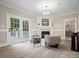 Cozy living room features fireplace, mounted television, and French doors that lead to an outdoor area at 1511 Churchill Downs Dr, Waxhaw, NC 28173