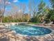 Backyard in-ground pool featuring lounge chairs, lush landscaping, and a wooden playset at 1511 Churchill Downs Dr, Waxhaw, NC 28173