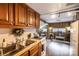 A kitchen featuring wooden cabinets, a double sink, and a view into the cozy living area with ample natural light at 167 Holly Harbor Trl # 169/170, Mount Gilead, NC 27306