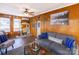 Cozy living room features wood-paneled walls, a ceiling fan, and a comfortable gray sofa at 167 Holly Harbor Trl # 169/170, Mount Gilead, NC 27306