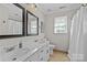 Bright bathroom featuring a double vanity with white countertops, a window, and a shower with curtain at 2016 Monaghan Ct, Matthews, NC 28105