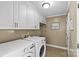 Clean and organized laundry room with white cabinets, washer, and dryer at 2016 Monaghan Ct, Matthews, NC 28105
